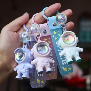 Luminous astronaut keychain with silicone space strap in blue, purple, and pink colors