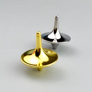 Macro shot of silver and gold metal fidget spinning tops with a mirror-polished finish