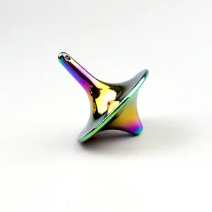 Macro view of rainbow plated metal spinning top with iridescent gradient finish