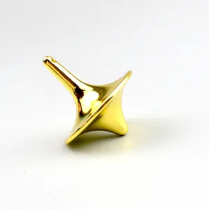 Macro shot of a polished gold metal spinning top with a glossy mirror-like finish