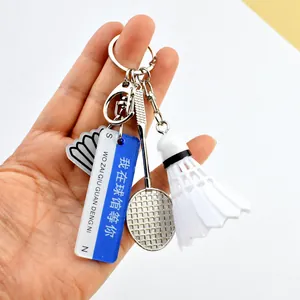 Badminton racket keychain with shuttlecock and engraved motivational tags in hand