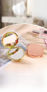 Close-up of golden and rose gold folding pocket mirrors with polished metal surface
