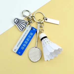 Dettaglio portachiavi badminton con volano, racchetta in metallo e targhetta blu
