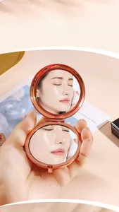 Detail of a rose gold folding makeup mirror with 2x magnification and HD glass