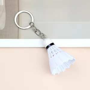 Macro shot of realistic white badminton shuttlecock keychain with silver metal ring