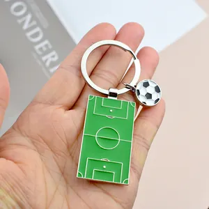 Metalen voetbalveld sleutelhanger met kleine voetbal in de hand voor de afmeting