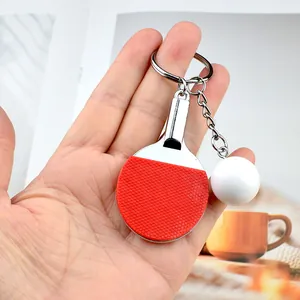 Miniature table tennis racket and ball keychain with red rubber texture and silver metal handle