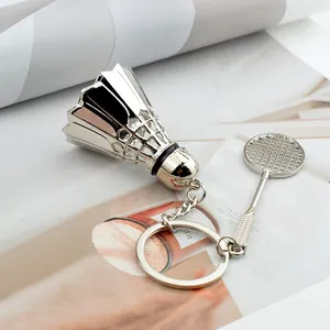 Close-up of silver metal badminton shuttlecock and racket keychain on fashion magazine