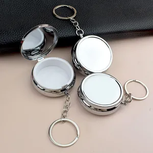 Détail du pilulier en métal argenté avec miroir interne et porte-clés pratique