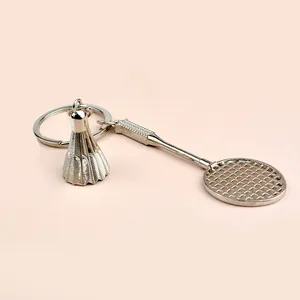Detailed shot of a silver alloy badminton racket and shuttlecock keychain with keyring