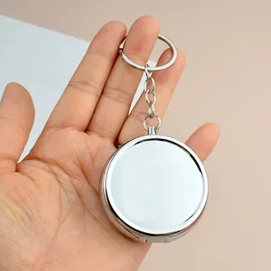 Mini boîte à pilules ronde en métal argenté avec porte-clés et finition miroir poli
