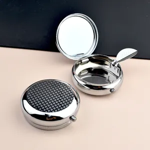 Portable round silver metal ashtray with geometric pattern and built-in mirror
