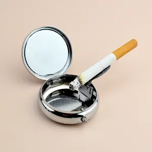Portable silver round metal ashtray with a folding cigarette holder and flip cover