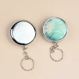 Portable metal retractable keychain with textured silver and green marble patterns