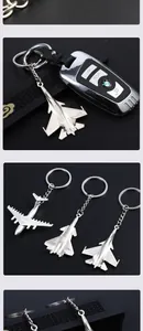 Detail of silver alloy fighter jet keychains displayed in a premium black gift box