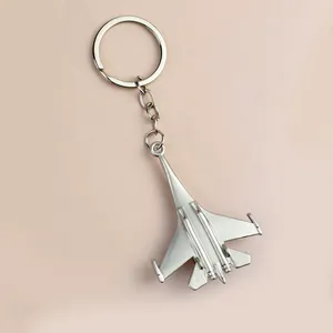 Silver matte metal fighter jet keychain featuring a modern aircraft model design