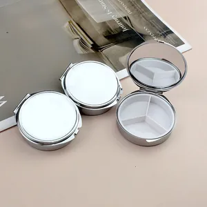 Détail de la boîte à pilules ronde en métal argenté avec trois compartiments et miroir