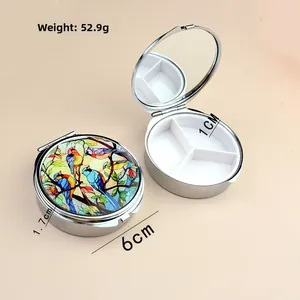 Portable silver metal pill box with colorful bird art lid, three slots and interior mirror