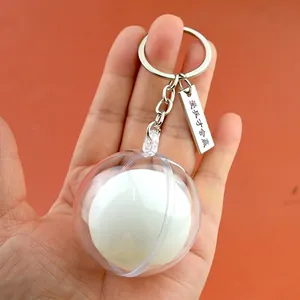 Miniature table tennis ball keychain with engraved metal tag on vibrant orange background