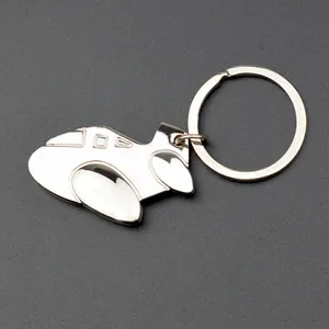 Polished silver metal airplane model keychain with round ring on grey background