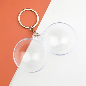 Detail of transparent acrylic ball keychain with silver metal rings on a two-tone background