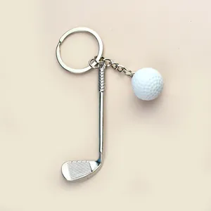 Dettaglio del portachiavi con mazza da golf argento e pallina bianca dalla texture reale