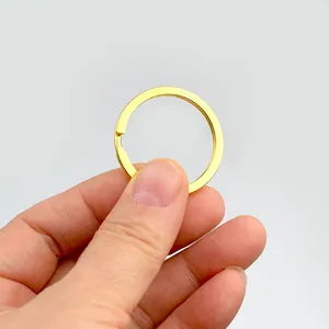 Detailopname van een kleine gouden metalen platte sleutelring met dubbele lus