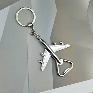 Detail shot of the silver airplane bottle opener keychain on a gray textured surface