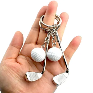 Set portachiavi creativo con mazza e pallina da golf tenuto in mano come accessorio
