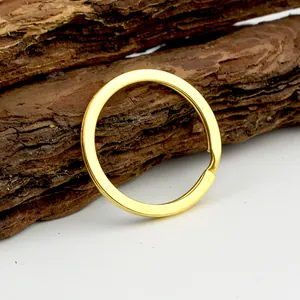 Gepolijste gouden metalen splitring sleutelhanger op decoratieve boomschors