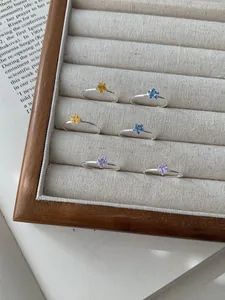 Makroaufnahme bunter sternförmiger Edelsteinringe aus S925 Silber auf Vintage Buch