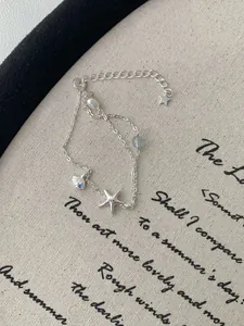 Close-up of S925 silver ocean bracelet with starfish, shell, pearl and blue gemstone