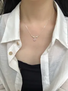 Gros plan d'un collier en argent S925 avec pendentif fleur rose sur un mannequin femme