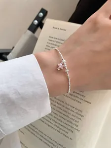 Vue détaillée d'un bracelet en argent S925 avec un pendentif étoile rose au poignet