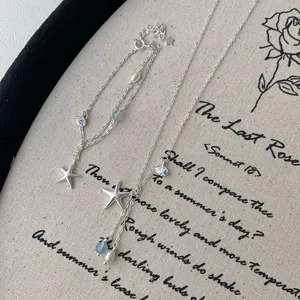 S925 silver jewelry set with starfish, shell charms, pearls, and blue beads on canvas