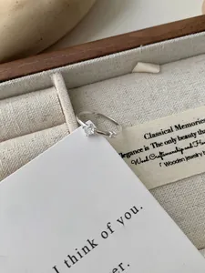 Detail van een verstelbare S925 zilveren ring met fonkelende zirkoon in houten doosje