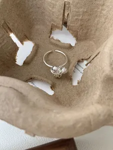Detailopname van een S925 zilveren ring met onregelmatige touwknoop en kleine kraal