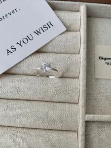 Gedetailleerde close-up van een zilveren ring met grote ronde solitair en gehamerde band