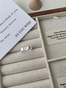 Detail van een zilveren ring met ovale witte edelsteen in een fluwelen doosje