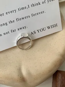 Detail van onregelmatige S925 zilveren ring met ovale witte edelsteen en handgemaakte textuur