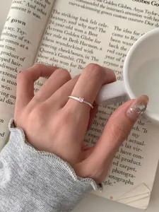 Dettaglio dell'anello minimalista in argento S925 con piccolo zircone rosa al dito