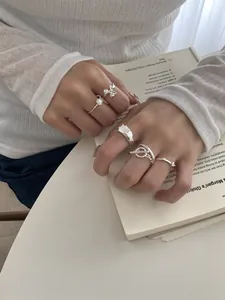 Detailweergave van S925 zilveren ringen met bloemdessin en onregelmatige golven