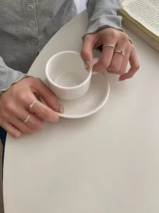Dettaglio ravvicinato di quattro anelli minimalisti in argento S925 con pietre colorate