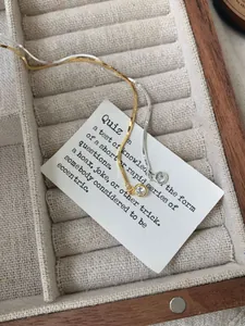 Macro detail of gold and silver snake chain necklaces with zircon pendants on tray