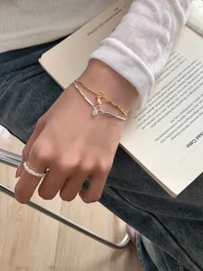 Close-up of stacked S925 silver bubble bracelets and a pavé ring on a model's hand