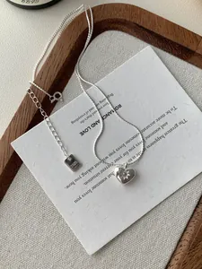 Dettaglio della collana a cuore in argento S925 con zircone a stella su sfondo neutro