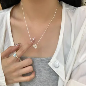 Elegante collana a cuore in argento sterling S925 indossata da modella con anello azzurro