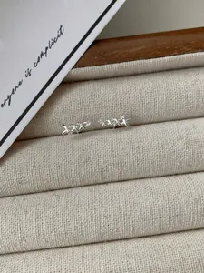 Dettaglio orecchini S925 argento con pavé di cristalli a forma di X su velluto
