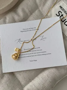Detail of a vintage-style gold S925 silver necklace with a matte gourd and Fu pendant