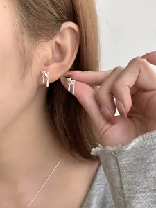 Dettaglio degli orecchini a cuore in argento S925 con pendenti in zircone sul lobo